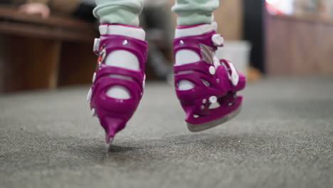 close-up of someone walking in purple ice skates with ash-colored trousers, the scene captures the dynamic motion and preparation for ice skating