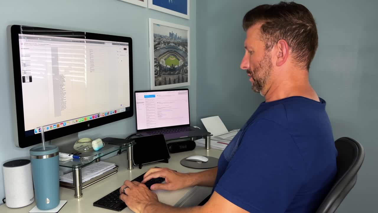 hombre adulto caucásico barbudo independiente sentado en el espacio de trabajo de la oficina en casa navegando por la pantalla de la computadora