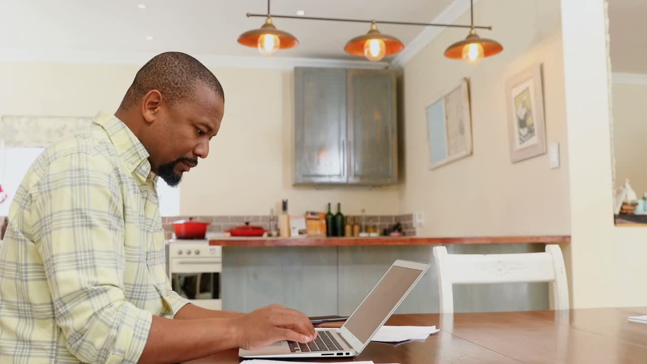 Man using laptop in kitchen 4k