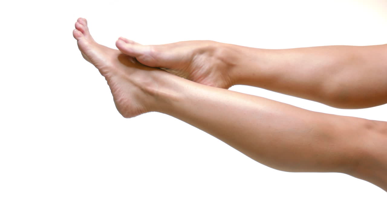 Primo piano di gambe lisce di donna con pelle sana su sfondo bianco