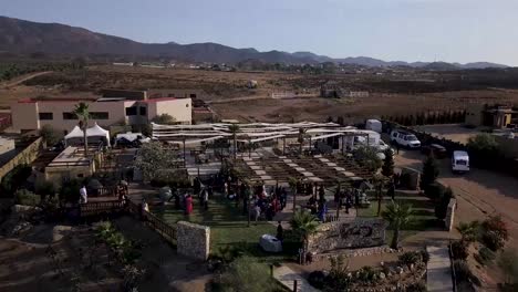 Drone-taking-a-close-view-of-a-wedding-party-on-a-big-house-in-the-middle-of-the-valley