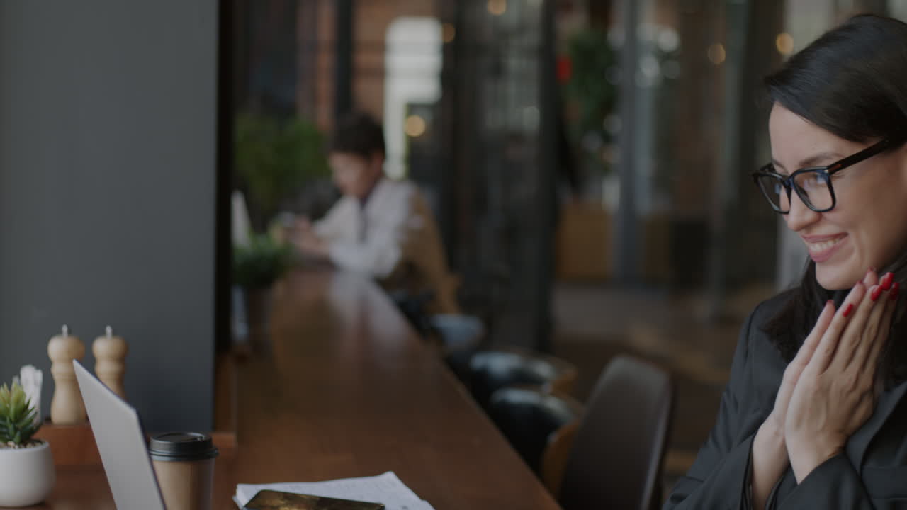 mujer trabajando en una computadora portátil en un café