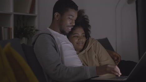 young couple choosing a movie to watch on the laptop