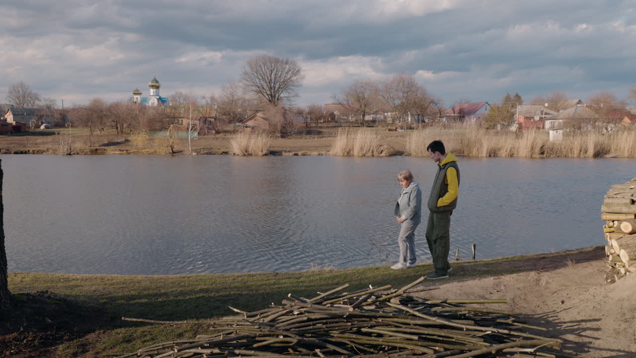 한 부부가 마을의 강을 따라 고 있다