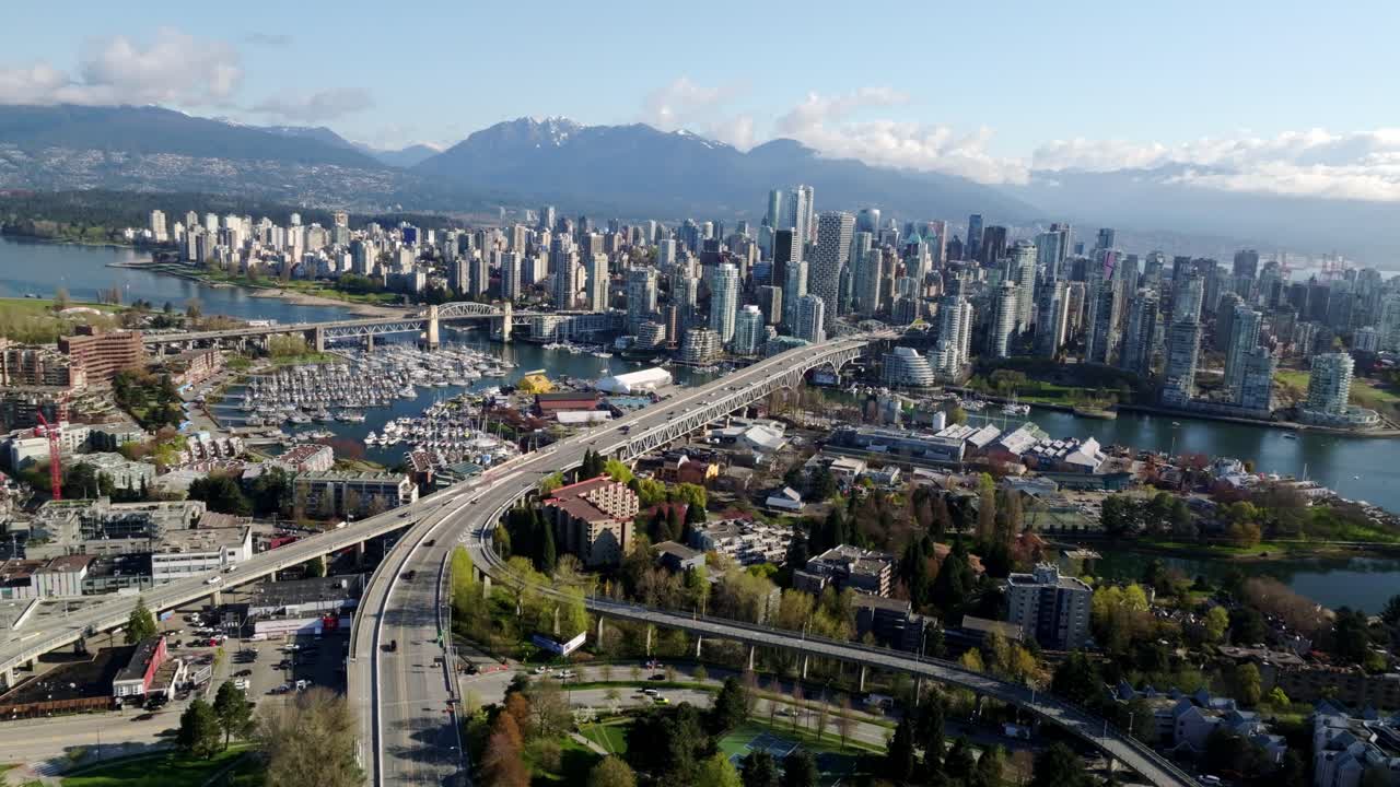 A Beautiful View of Modern Towers, a Busy Marina, and Mountain Landscapes by the Water in Vancouver, British Columbia, Canada - Wide Shot