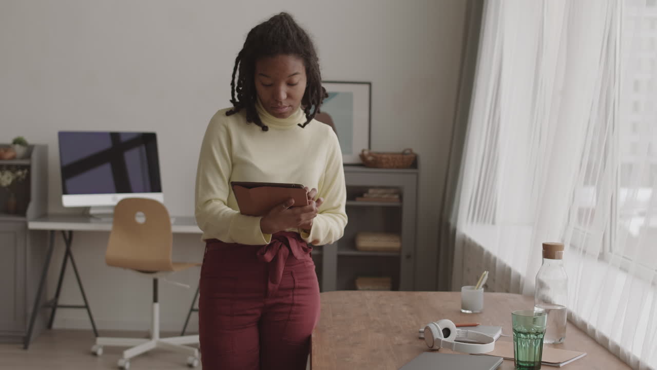 Young African Woman Using Digital Tablet at Home