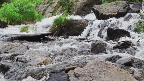 Slow-motion-water-pouring-over-rocks