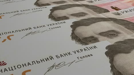 100 украинских гривень на фоне банкнот. много банкнот.