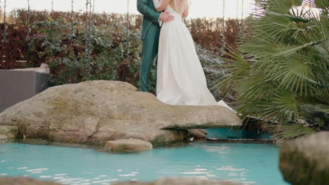 Couple-by-pond-with-rocks-and-garden