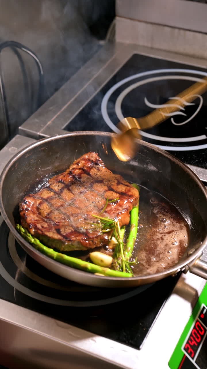 Fried steak with asparagus and garlic. Grilled steak with asparagus and garlic cooked in frying pan with smoke