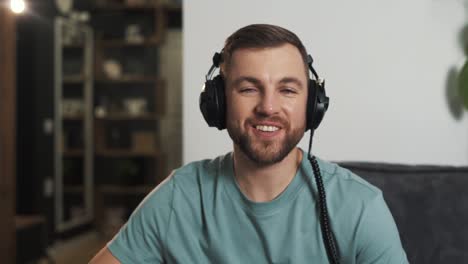 a young man in headphones greets and talks on a video call