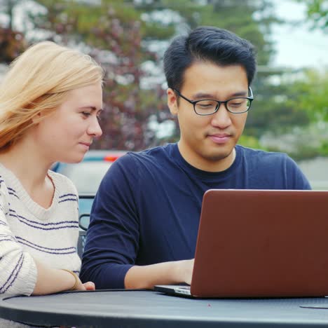 Los-Estudiantes-Trabajan-Con-Una-Computadora-Portátil-En-La-Mesa-De-Un-Café-De-Verano-5