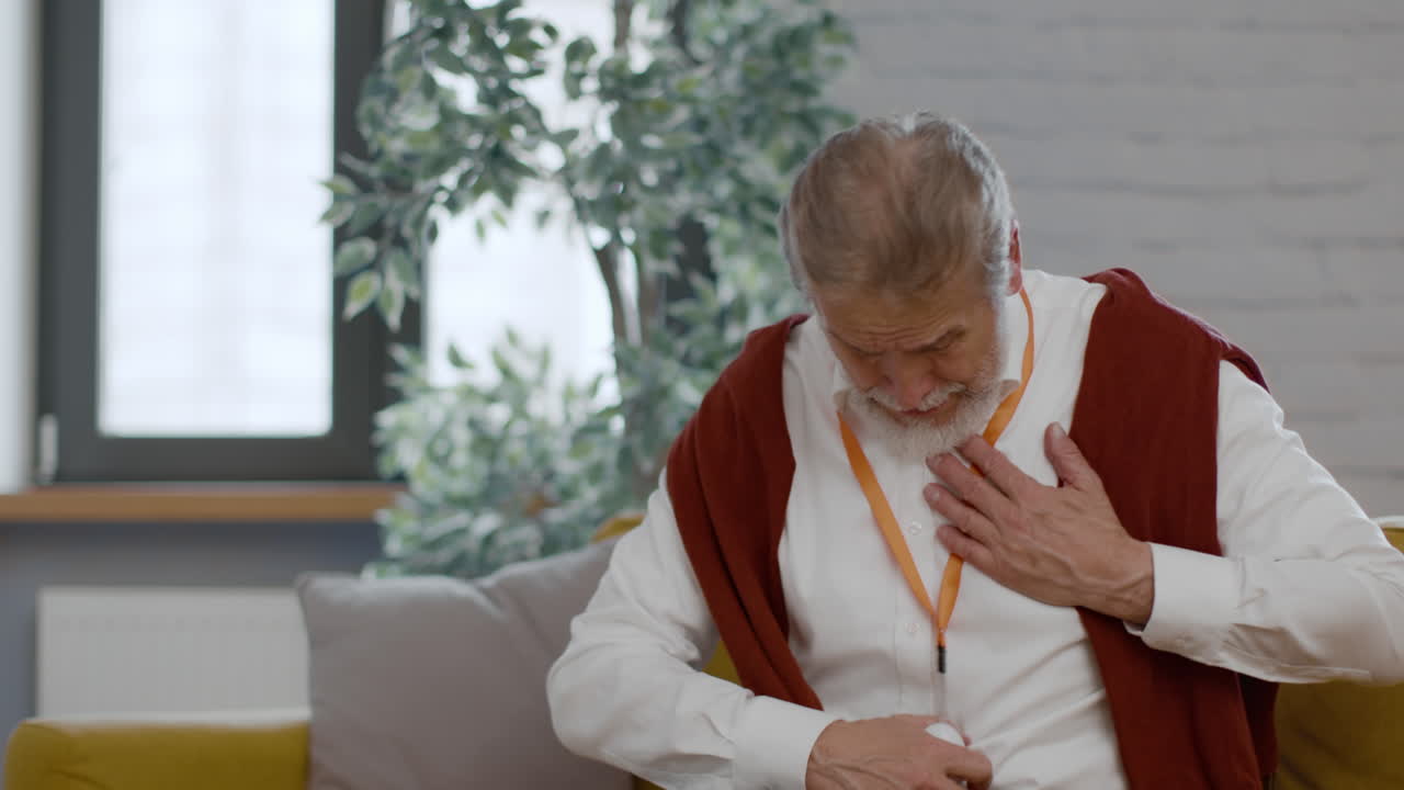 Elderly Man Experiencing Chest Pain with Medical Alert Device