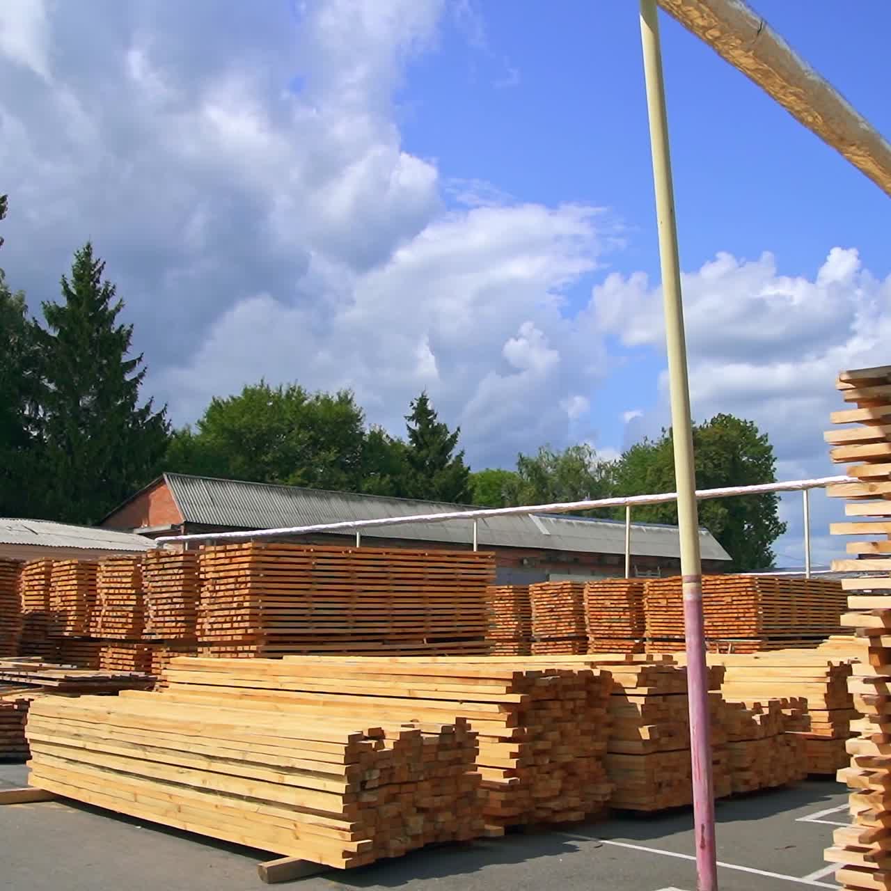 Numerous piles of timber bars stored outdoors. Stacks of wooden sticks are kept for future processing at plant