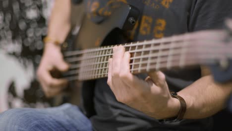 close up of a professional bass guitar player playing in a recording studio a bass riff finger style with thumb