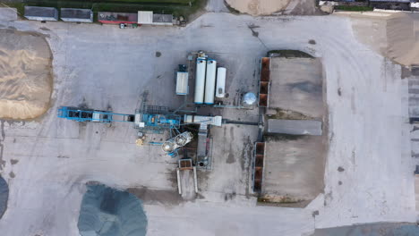 Industrial-machinery-in-asphalt-making-factory,-aerial-top-down-view