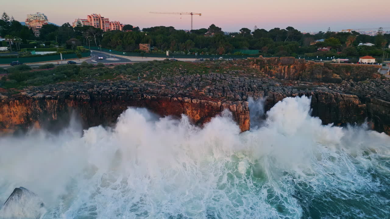 드론 뷰: 바위가 있는 해안선에 위치한 해안 도시. 폭풍우가 몰아치는 바다 절벽.