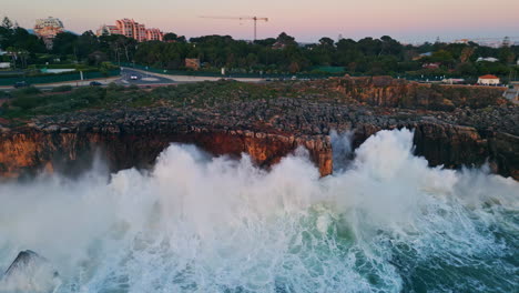 drone vista ciudad costera colocada en la costa rocosa. océano tormentoso chocando con los acantilados
