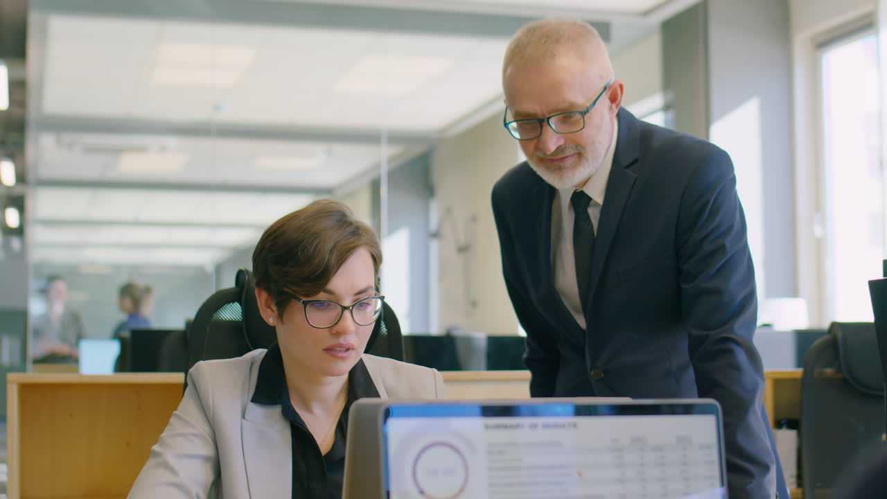Senior Businessman Helping Female Coworker in Office