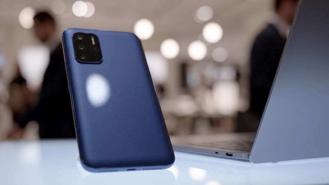 Stylish Smartphone and Laptop Setup - A Modern Tech Display Featuring a Deep Blue Phone Case Against a Subtle Background of Soft Lighting and Minimalist Design