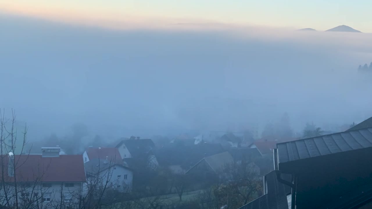 백그라운드에서 일출과 함께 아침에 도시를 통해 이동하는 안개와 함께 timelaps