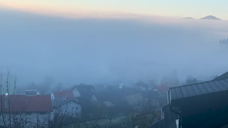 Zeitraffer-Mit-Nebel,-Der-Sich-Morgens-Durch-Die-Stadt-Bewegt,-Mit-Sonnenaufgang-Im-Hintergrund