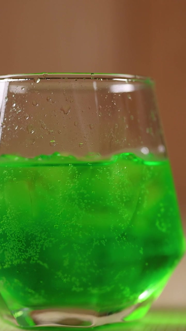 Bevanda verde con cubetti di ghiaccio in un bicchiere