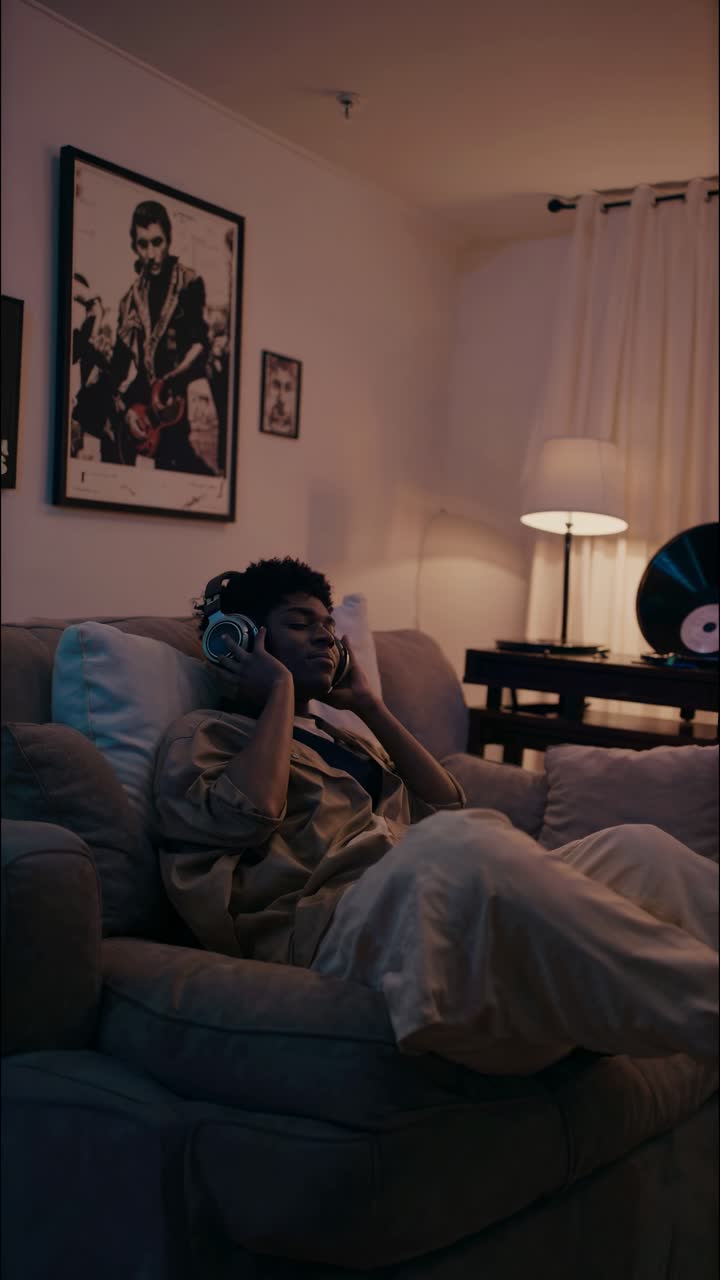 A cozy living room scene captured at eye level, featuring a person relaxing with headphones