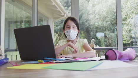 Mädchen-Mit-Gesichtsmaske-Und-Laptop-Zu-Hause