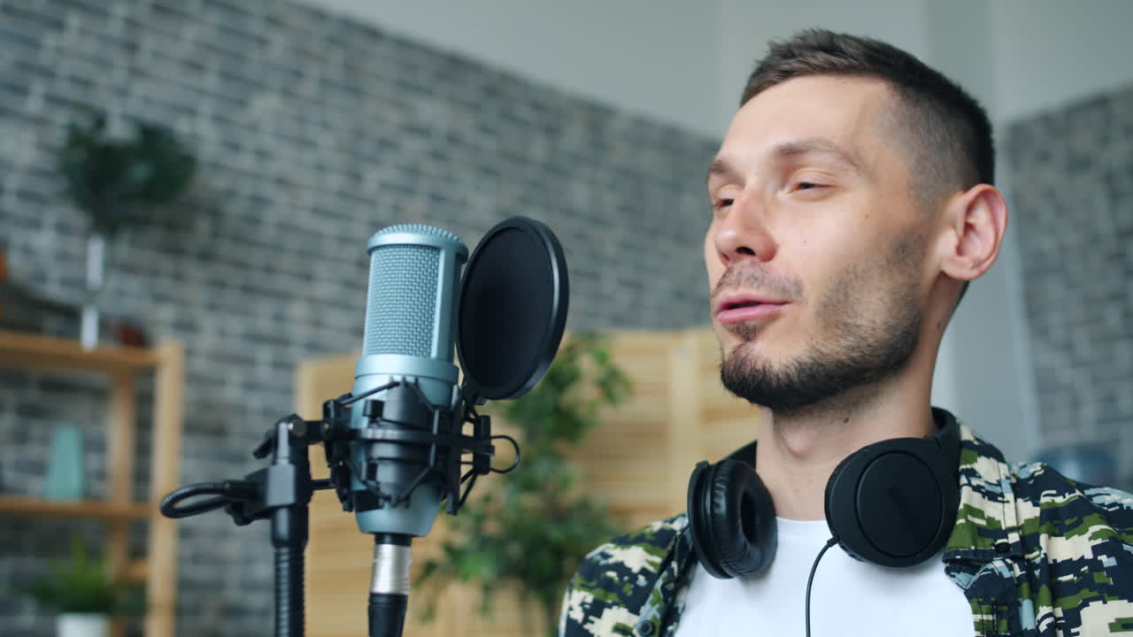 hombre cantando en el micrófono en el estudio de grabación