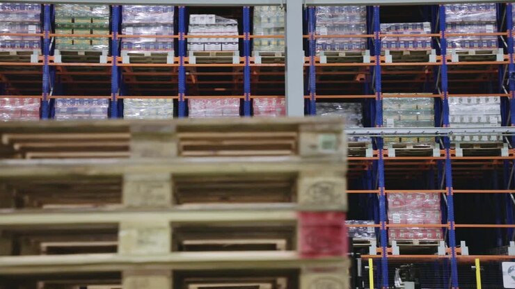 Prodotti di diversi colori stoccati all'interno di un magazzino, pronti per essere spediti.