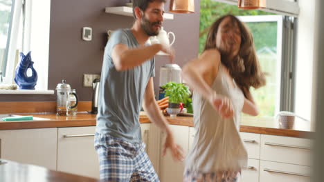 Joven-Pareja-Emocionada-Bailando-En-Su-Cocina