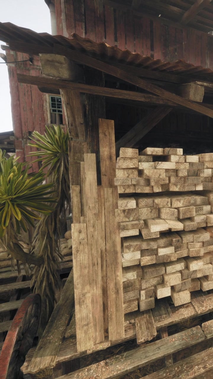 Cataste di legno sono impilate accanto a un edificio in un cantiere edile in una giornata di sole.