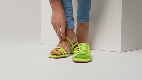 close up of female social media influencer producing user generated content putting on beautiful pair of green shoes 4