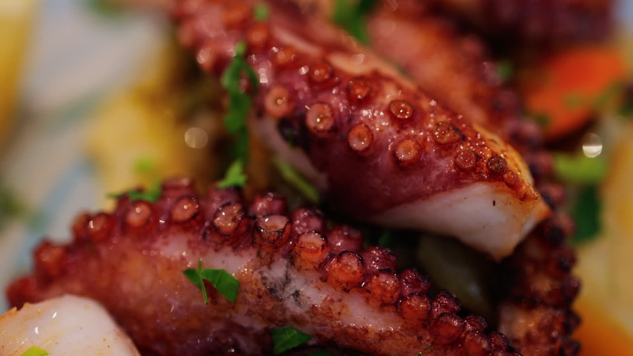 Close up of grilled octopus on a puree and a piece of lemon at a restaurant