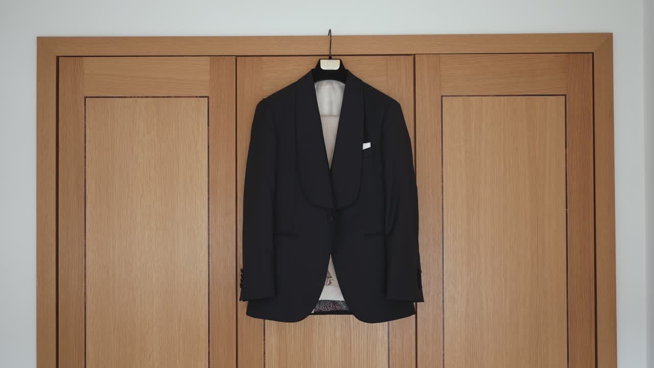 elegant black suit jacket hung on wardrobe in soft natural light