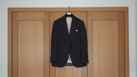 elegant black suit jacket hung on wardrobe in soft natural light