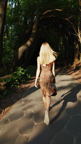 mujer caminando por un camino del bosque