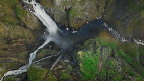 voringsvossen waterfall cascading over rocky cliffs in lush norway landscape , aerial view