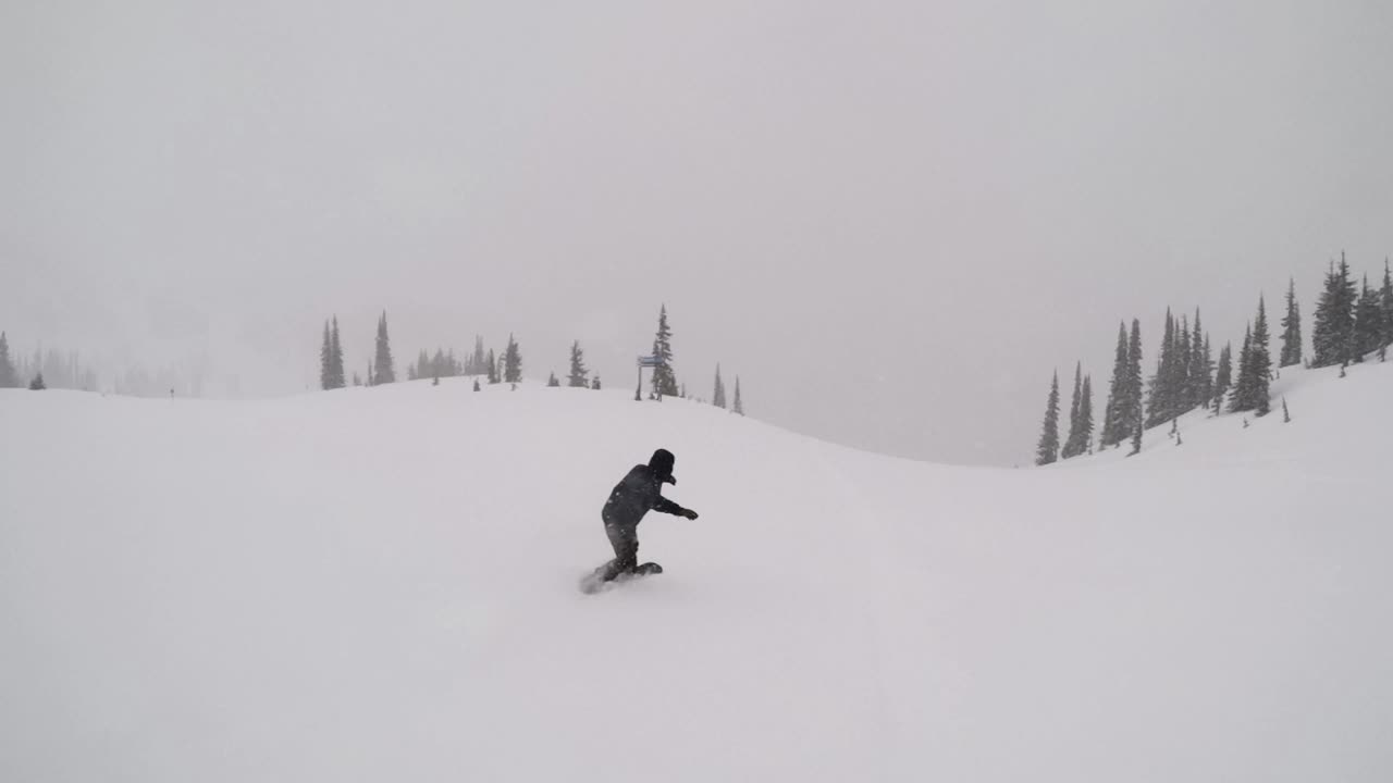 Snowboarder riding deep powder snow on a cloudy day