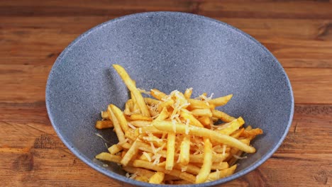 Detaillierte-Nahaufnahme-Von-Pommes-Frites-Mit-Geriebenem-Käse,-Die-An-Einen-Tisch-Geliefert-Werden