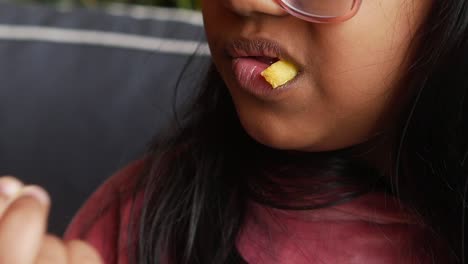 una joven disfrutando felizmente de un chip de patata