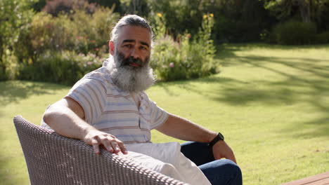 relaxing outdoors, senior man sitting on chair in sunny garden