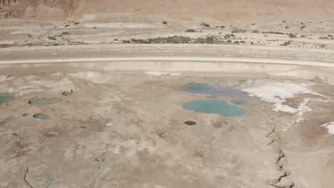 aerial view of cracked earth and sinkholes in a desert landscape