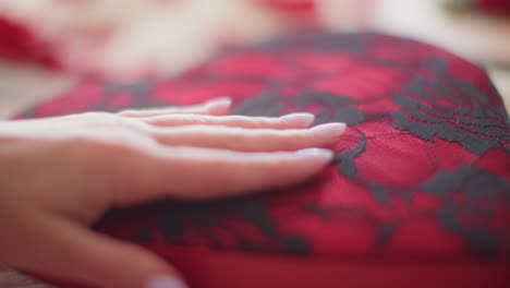 Woman&#039;s hand feeling black and red lacey Valentine&#039;s Day gift box slow motion