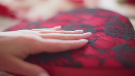 woman's hand feeling black and red lacey valentine's day gift box slow motion