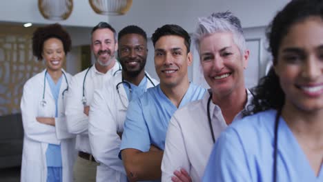 Portrait-of-diverse-male-and-female-doctors-standing-in-hospital-corridor-smiling-to-camera