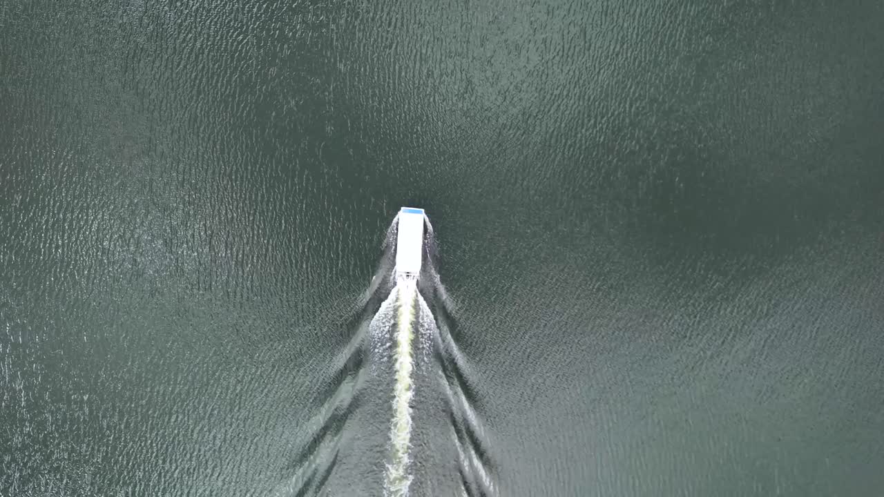 Drone top view of tourist boat on Presa Calles heading to Cristo Roto monument in San José de Gracia, Aguascalientes, Mexico. Pueblo Mágico attraction, cultural and religious landmark
