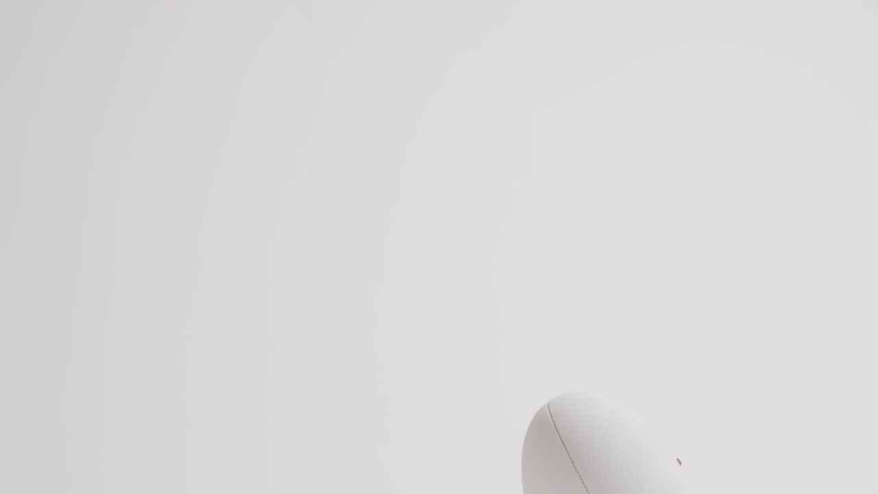 pelota de rugby blanca en patear tee en fondo blanco con espacio de copia, cámara lenta