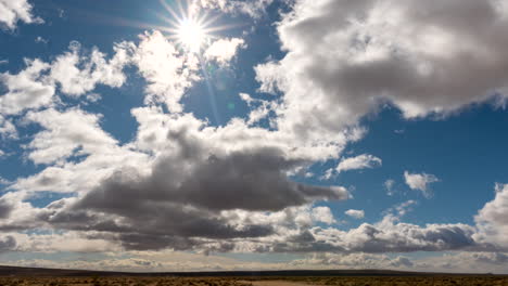 the sun shines through the overcast sky in this dramatic cloudscape time lapse over the mojave desert landscape